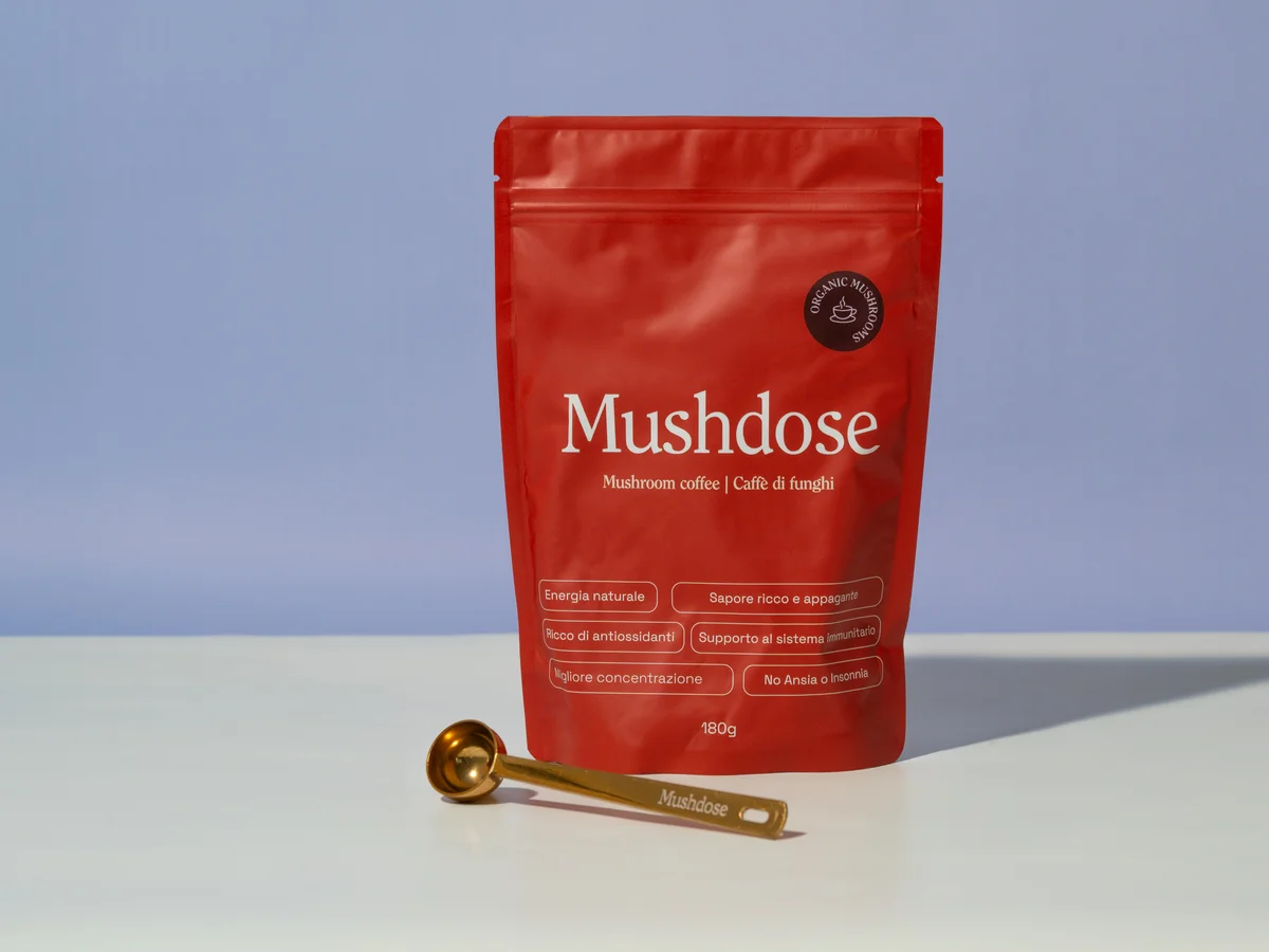 Le confezioni rosse Mushdose, il caffè e il misurino nello shooting del brand
