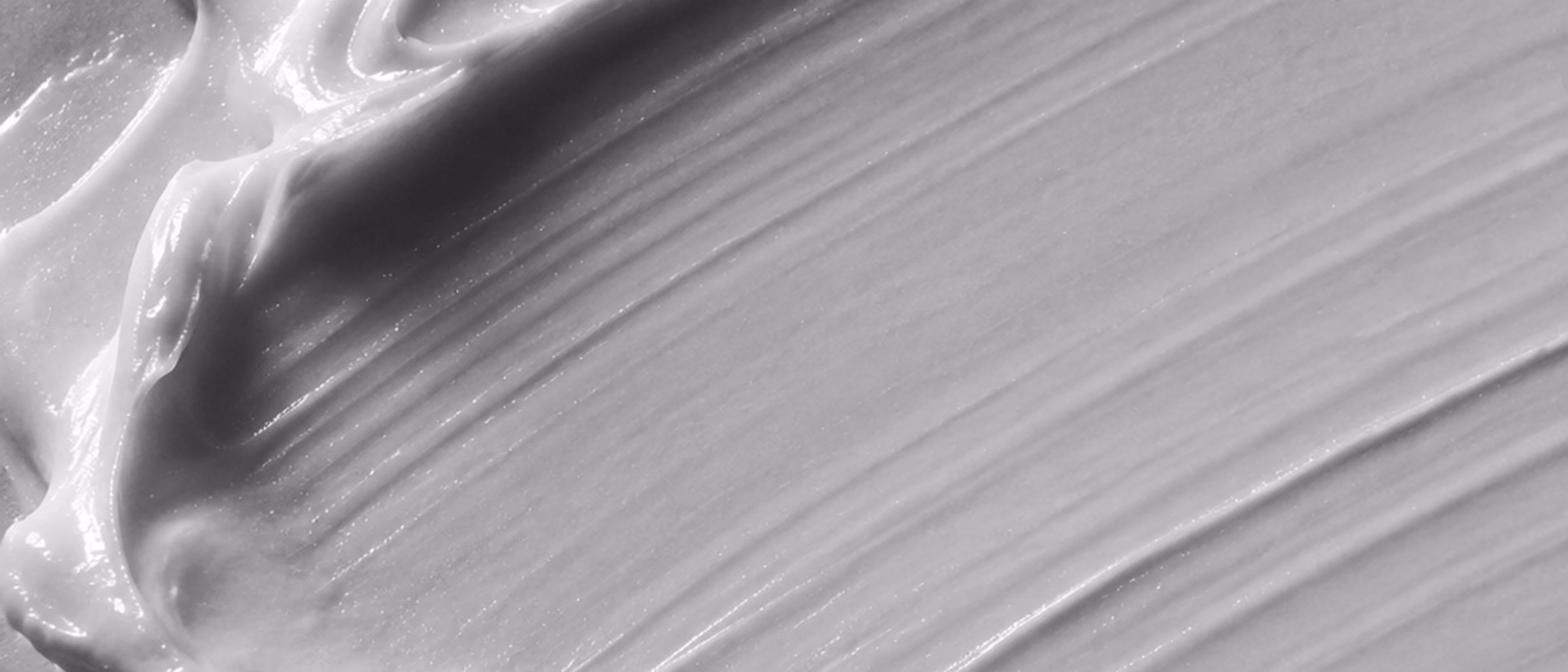 Black-and-white macro of a cosmetic cream swipe