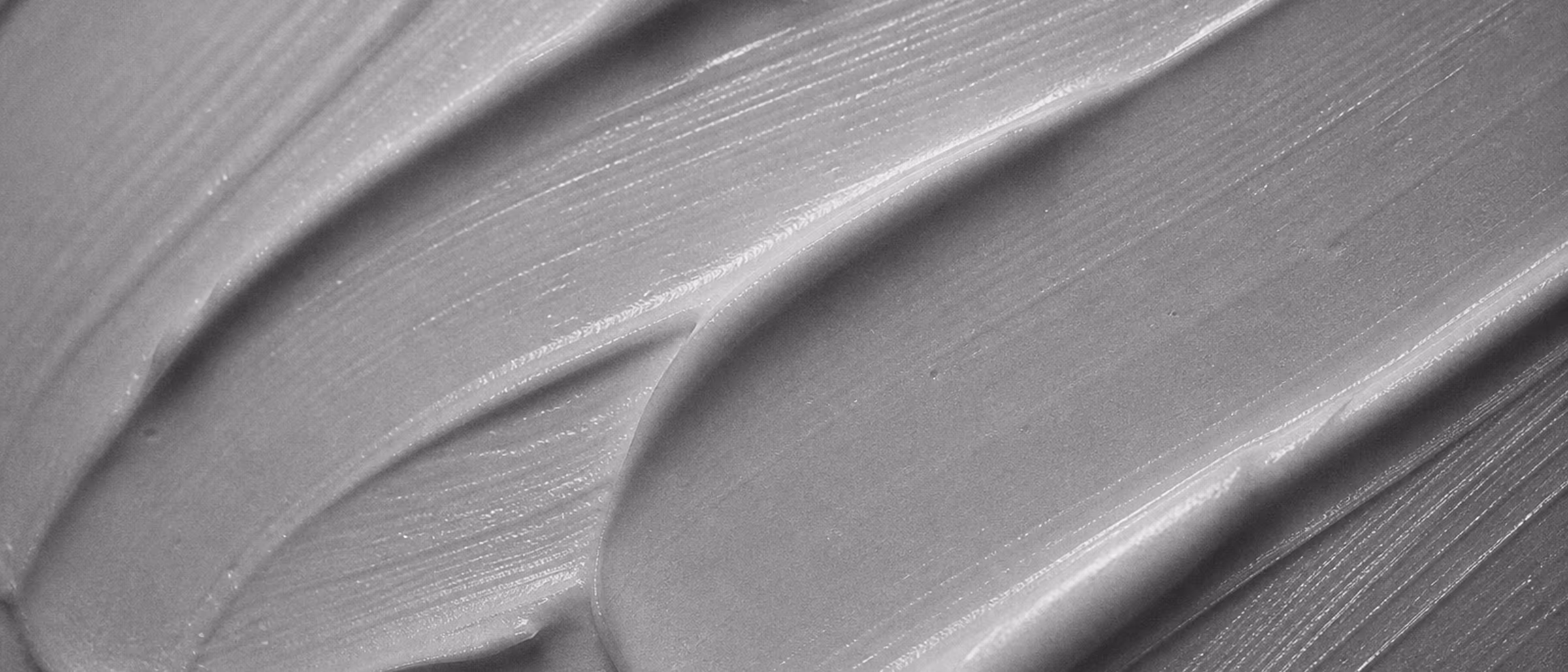 Black-and-white macro of a cosmetic cream swipe